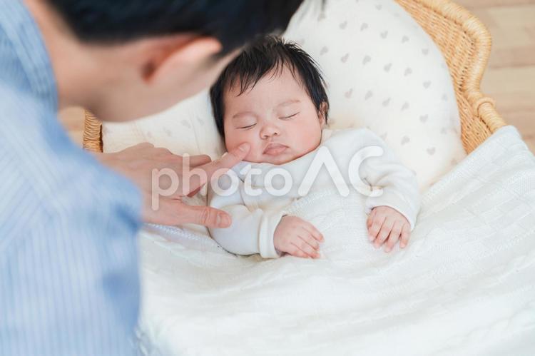 眠る赤ちゃんの頬を触る男性 赤ちゃん,ベビー,寝顔の写真素材