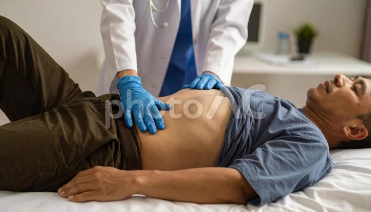 男性患者の腹部の触診を行う医師 医師,診察,患者の写真素材