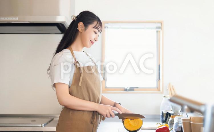 キッチンで料理をする笑顔の女性 女性,キッチン,料理の写真素材