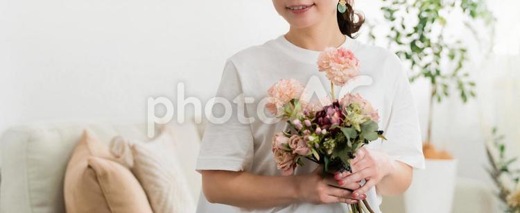 家のソファで花束を持つ日本人女性 母の日,花束,花の写真素材