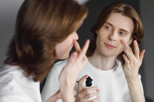 鏡を見ながら乳液を塗る若い男性 男性,外国人,欧米人の写真素材