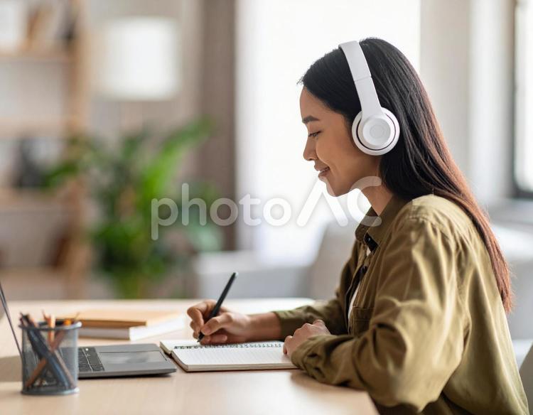 お気に入りの音楽を聴きながら勉強する女性 勉強,ノートパソコン,女性の写真素材