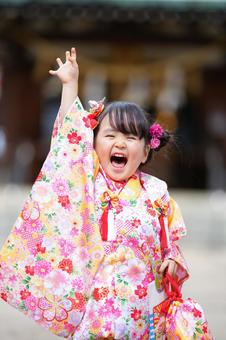 笑顔で手を振る七五三姿の女の子 笑顔で手を振る七五三姿の女の子 七五三,お参り,七五三参りの写真素材