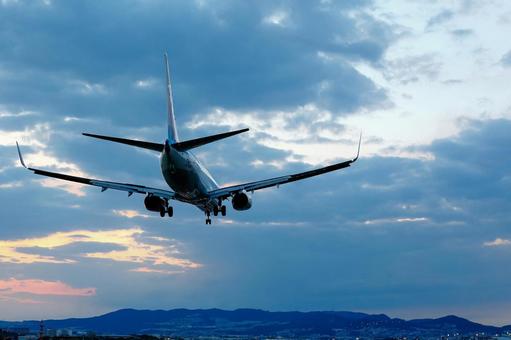 ほんのり茜色の空｜舞い降りる旅客機 飛行機,着陸,夕焼けの写真素材