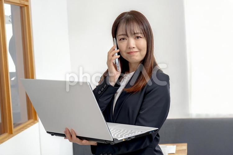 電話とPCと笑顔のビジネスウーマン 電話,スマートフォン,スマホの写真素材