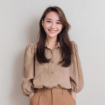 窓際で笑顔を見せるブラウン系の服の女性 窓際で笑顔を見せるブラウン系の服の女性の写真