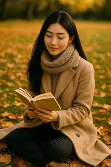 落ち葉の上で読書する女性(秋・全身) 落ち葉の上で読書する女性(秋・全身)の写真