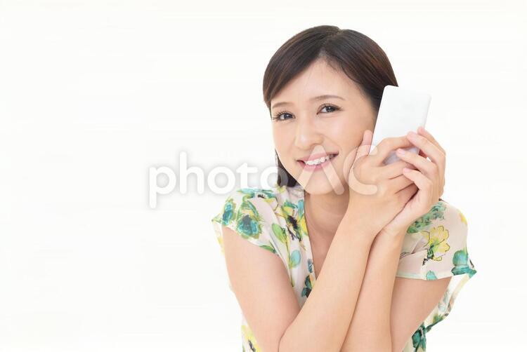 スマートフォンを持つ笑顔の女性 女性,スマートフォン,女の写真素材