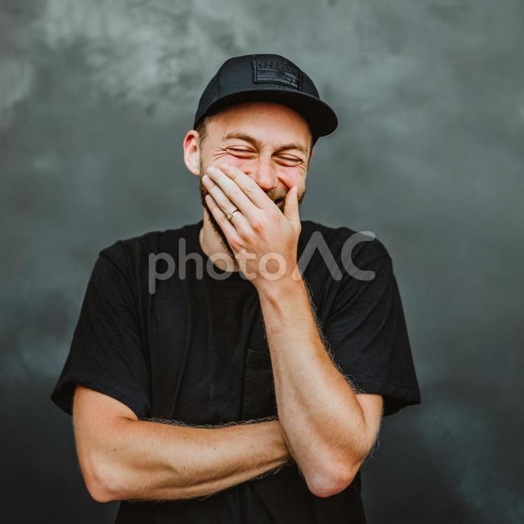 黒いキャップをかぶって笑顔を見せる男性 男性,笑う,笑顔の写真素材