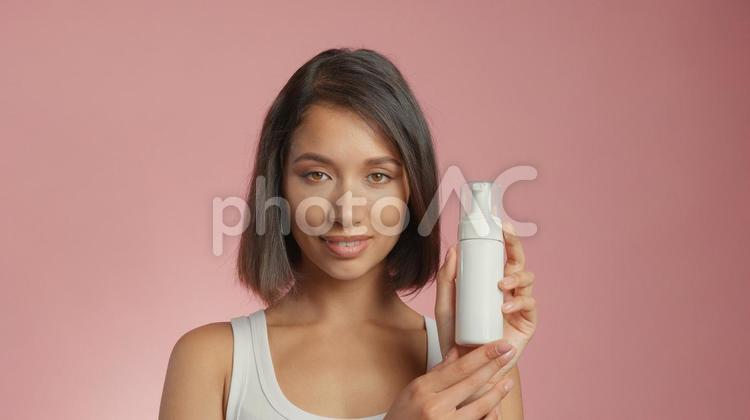 泡ポンプボトルを見せているカメラ目線の女性 女性,外国人,アジア人の写真素材