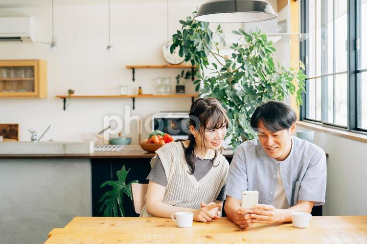 スマホを見る男性と女性（コーヒー） スマホ,夫婦,スマートフォンの写真素材