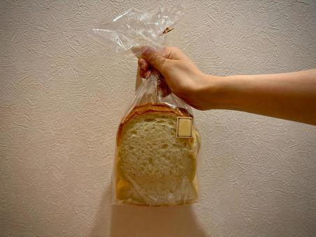 袋に入った食パンを持つ 袋に入った食パンを持つの写真