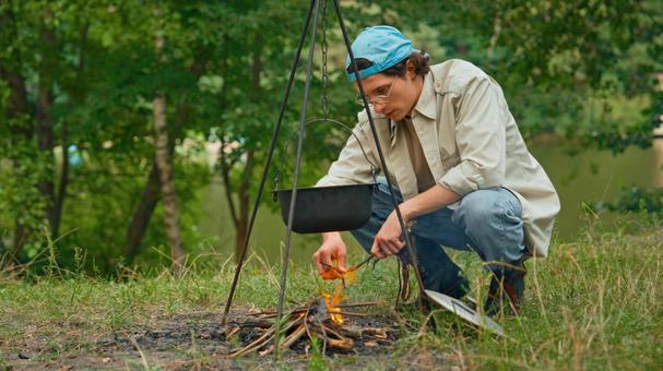 キャンプでしゃがむ男性 男性,外国人,鍋の写真素材