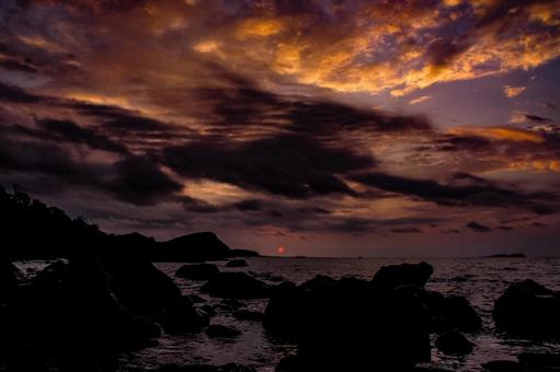 <素材>秋の暗い海へ沈む夕日 <素材>秋の暗い海へ沈む夕日の写真