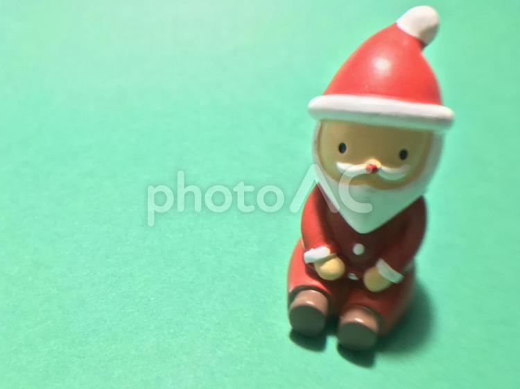 サンタクロースの人形（緑背景・座っている）、クリスマスイメージ サンタクロース,クリスマスイヴ,クリスマスの写真素材