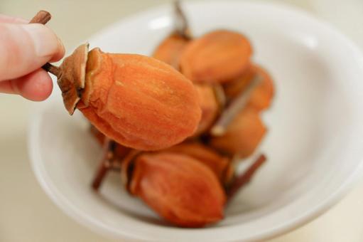 干し柿を持つ 干し柿,スイーツ干し柿,柿の写真素材