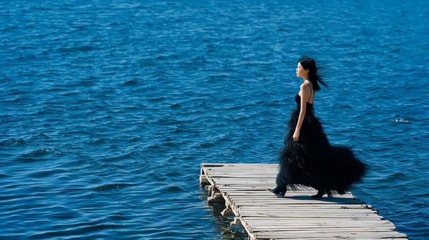 風に揺れるドレスと広がる海の風景 風に揺れるドレスと広がる海の風景の写真