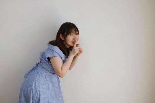内緒のポーズをする女性の写真