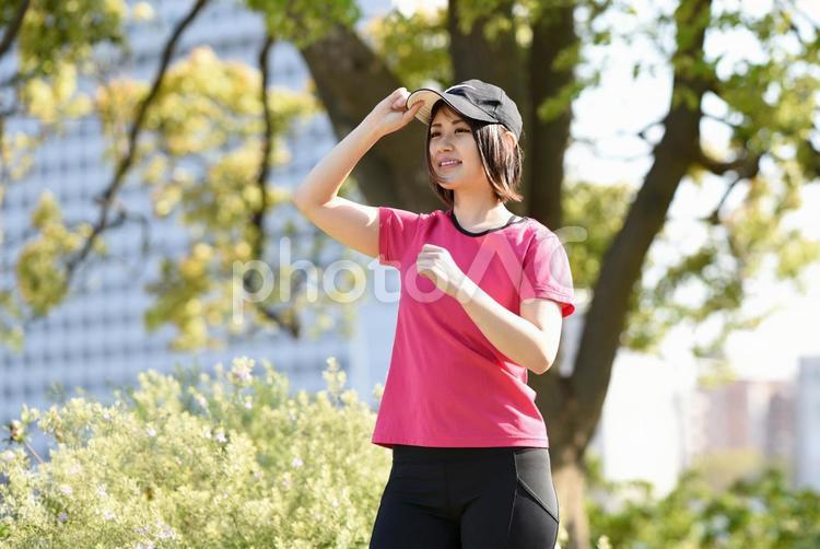 屋外で笑顔でジョギングする若い女性 女性,ランニング,ジョギングの写真素材