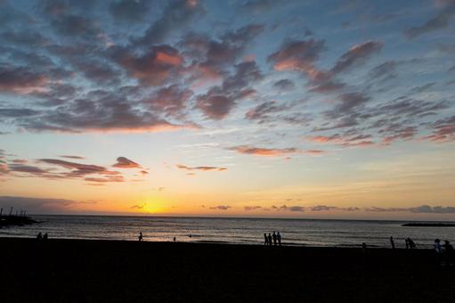 海に沈む夕日と人々のシルエット 夕日,夕焼け,海の写真素材