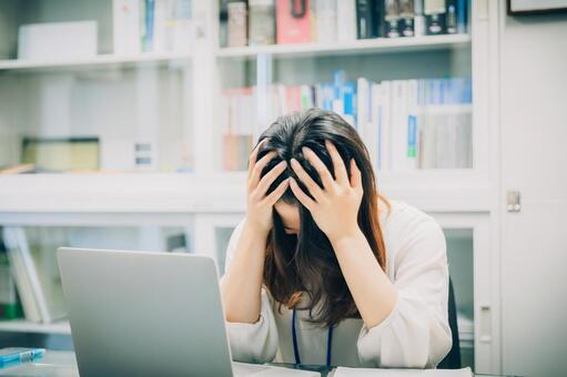 頭を抱えて悩むビジネス女性 悩む女性,働く女性,ストレスの写真素材