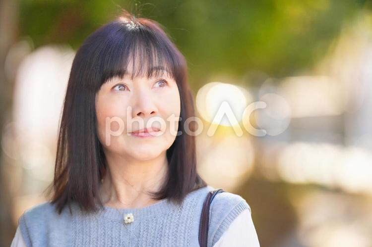 上の方の遠くを見る女性 女性,日本人,50代の写真素材