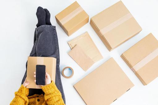 荷物の配送準備をする女性 荷物の配送準備をする女性 女性,顔無し,スマホの写真素材