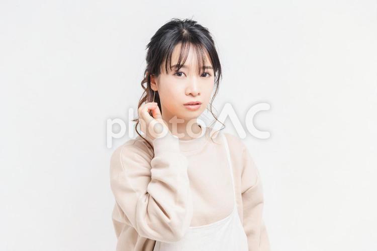 白い背景の前に立ってポーズをとる若い女性 女性,白背景,立つの写真素材