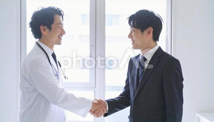 握手するビジネスパーソンと医者 握手,ビジネス,笑顔の写真素材