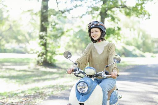バイクに乗る若い女性 バイクに乗る若い女性の写真