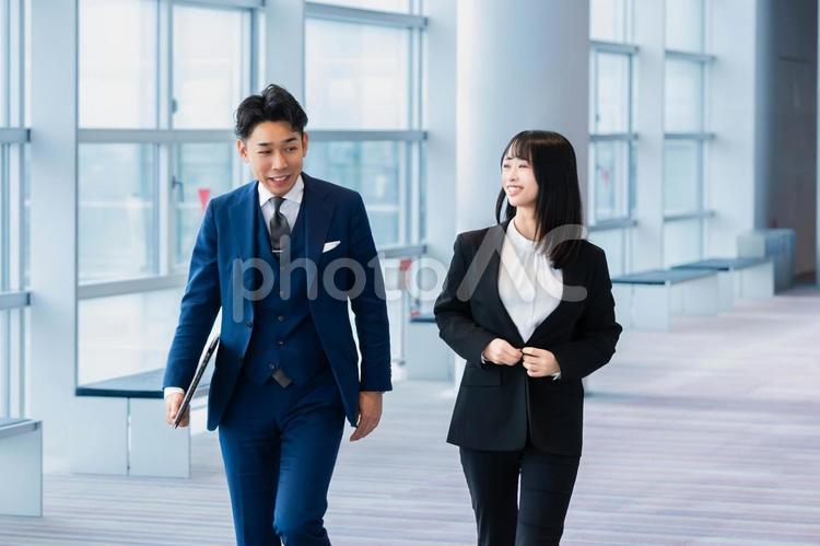 廊下を楽しそうに歩くビジネス系男女 ビジネスマン,男性,ビジネスの写真素材
