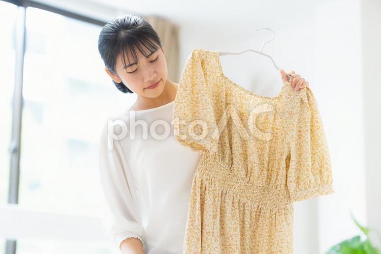 リビングで着替えをする大学生の女性 着替え,身支度,女性の写真素材