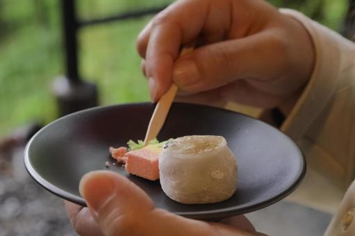 黒皿に盛られた和菓子を楽しむ女性の手元 和菓子,上生菓子,餅菓子の写真素材