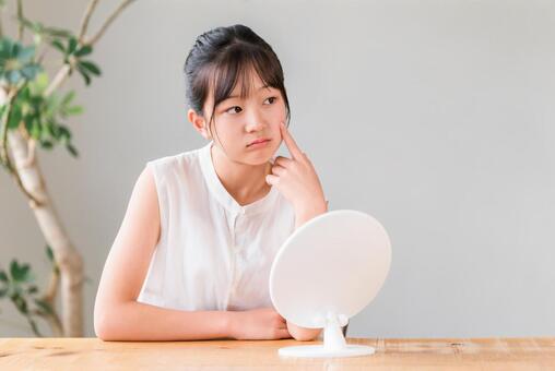 鏡を見る肌荒れ,ニキビに悩む小学生 肌荒れ,悩む,小学生の写真素材