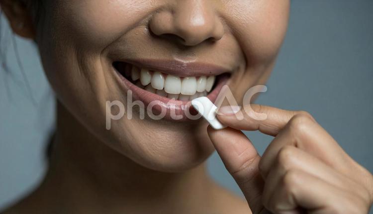 デンタルケアでガムを口にする女性 口,口元,ビューティーの写真素材