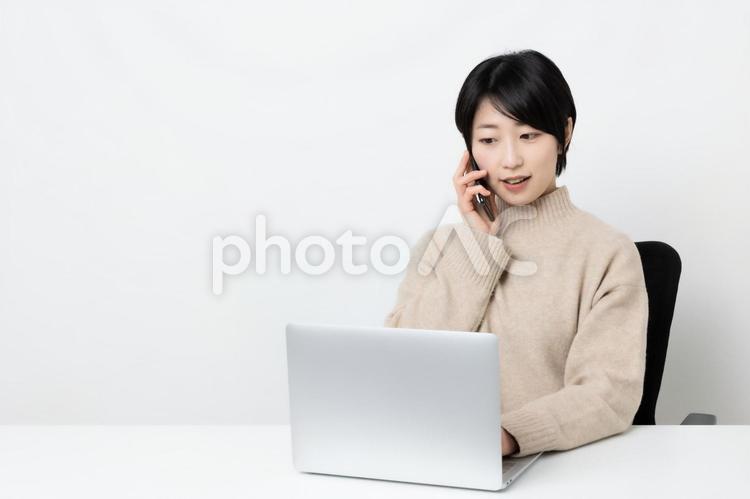 仕事をしながら電話をしている女性 女性,女子,女の写真素材