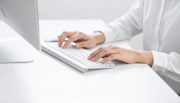 オフィスでキーボードを操作する女性の手元 オフィスでキーボードを操作する女性の手元の写真