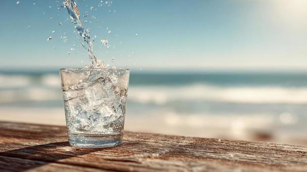 木製のテーブルに置かれたグラスと水 木製のテーブルに置かれたグラスと水の写真