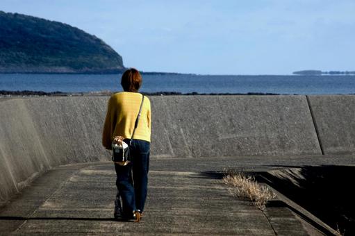 <人物>海辺をキックボードで散歩する女性 <人物>海辺をキックボードで散歩する女性 女性,人物,風景の写真素材