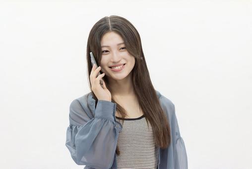 スマートフォンを使う若い女性 スマートフォンを使う若い女性 女性,スマホ,スマートフォンの写真素材