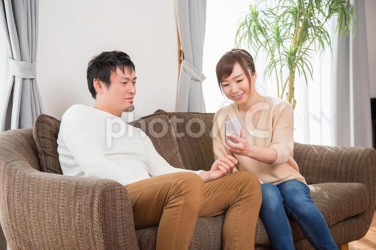 スマホを見る夫婦（笑顔） 家族,スマホ,インターネットの写真素材