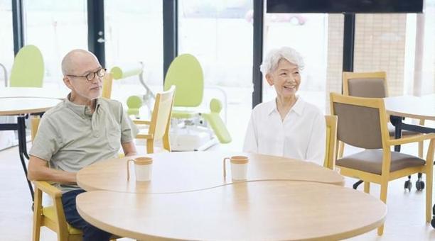 介護施設のデイルームで座る高齢者 介護施設のデイルームで座る高齢者 介護施設,座る,待つの写真素材