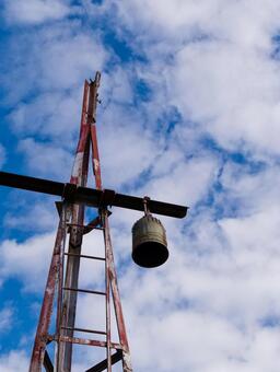 青空に映える古びた鐘楼と錆びた鉄塔 鐘,鐘楼,鉄塔の写真素材