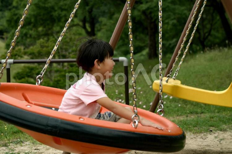 R＜素材＞公園でブランコで遊ぶ男の子 子供,ブランコ,笑顔の写真素材
