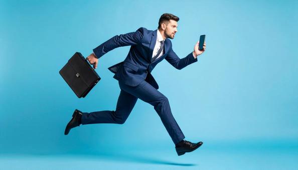 携帯電話を持って走るビジネスマン 携帯電話を持って走るビジネスマンの写真