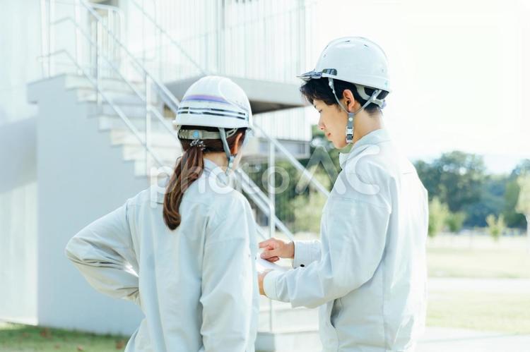 作業着で打ち合わせする男女　建設土建建築 作業服,作業着,働く男女の写真素材