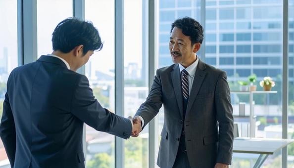 握手しながら謝罪するビジネスマン 握手しながら謝罪するビジネスマンの写真