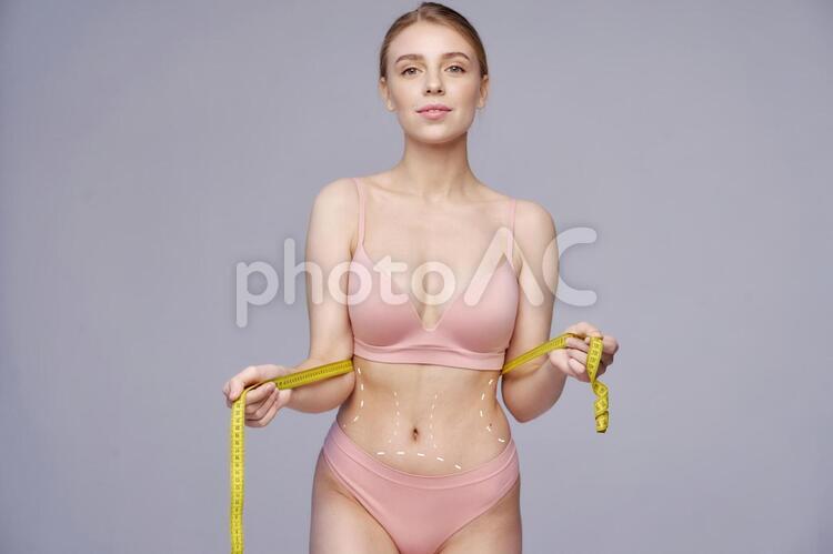 ウエストをメジャーで測っている女性 ウエスト,測る,女性の写真素材