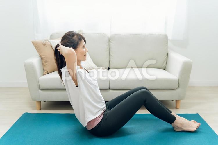 部屋で腹筋をするミドル世代の女性 腹筋,筋肉,お腹の写真素材