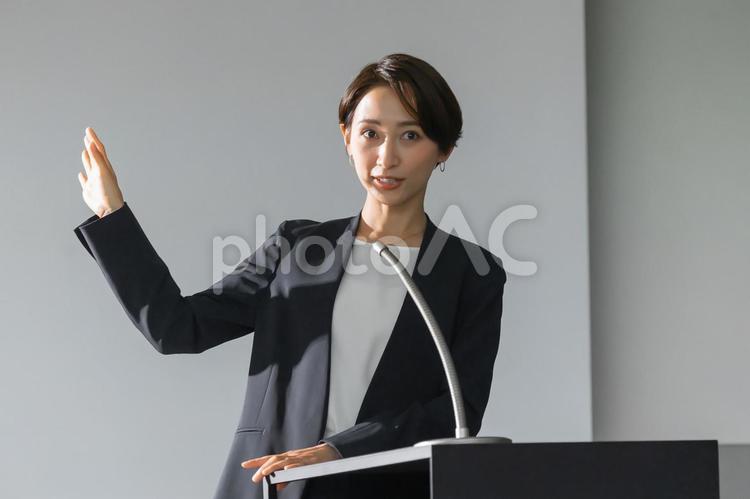 プレゼンする女性 講演,マイク,プレゼンの写真素材